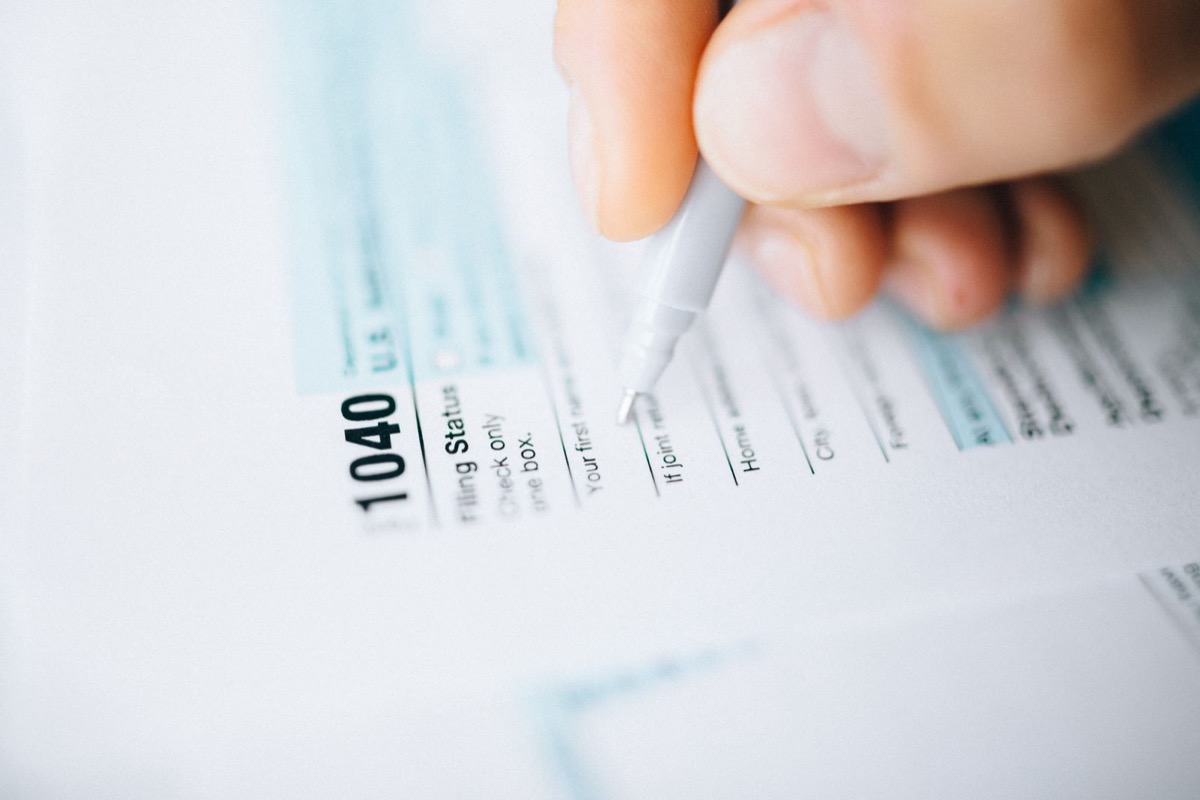 A pen on a tax form showing when you might owe capital gains on a home sale