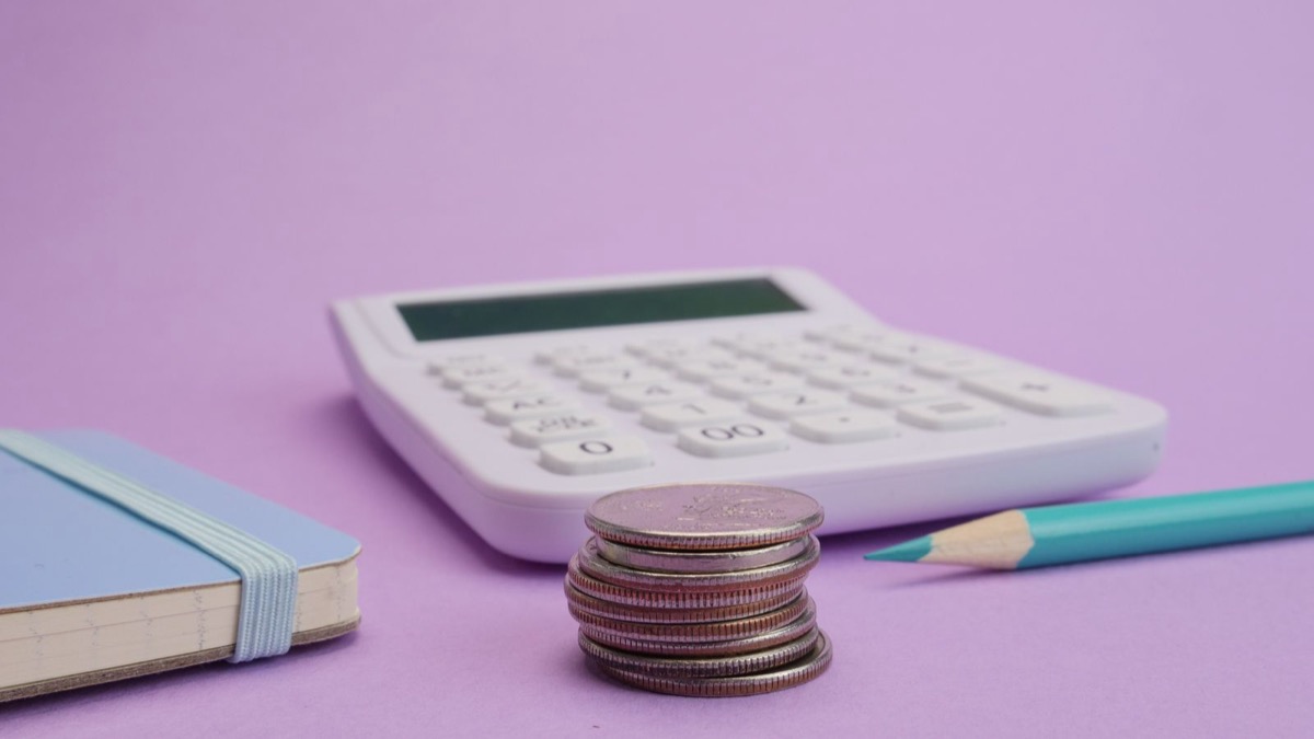 A small house model and coins showing how inherited and investment property taxes differ