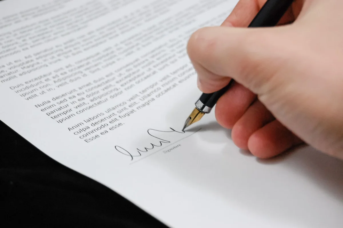 A person signing documents to add someone to a house title