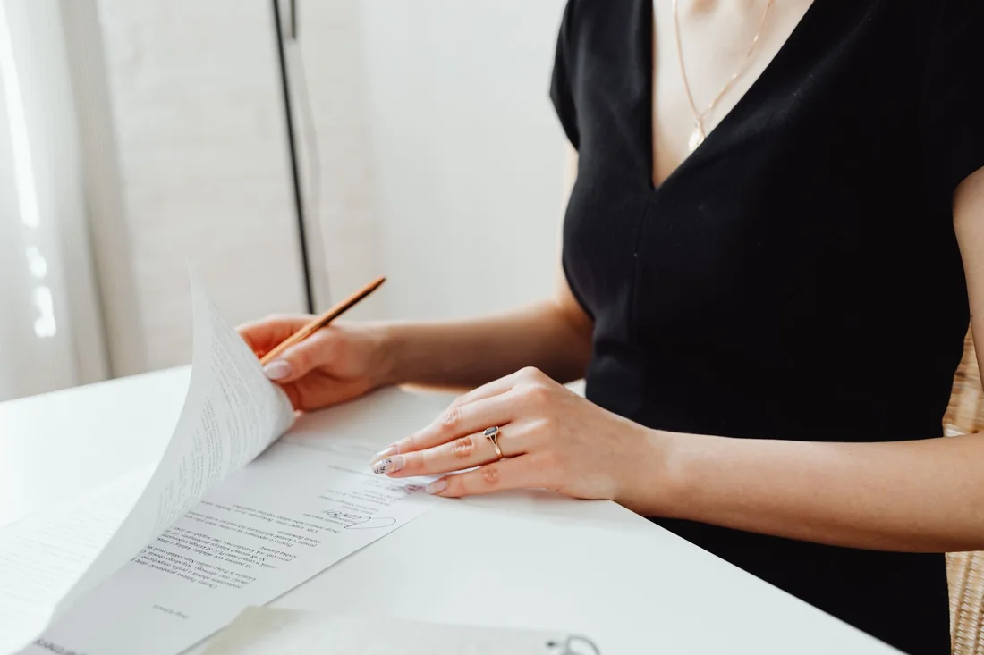 A seller reading a cash offer contract closely at a table, checking for we buy houses scams and cash home buyer red flags in Iowa