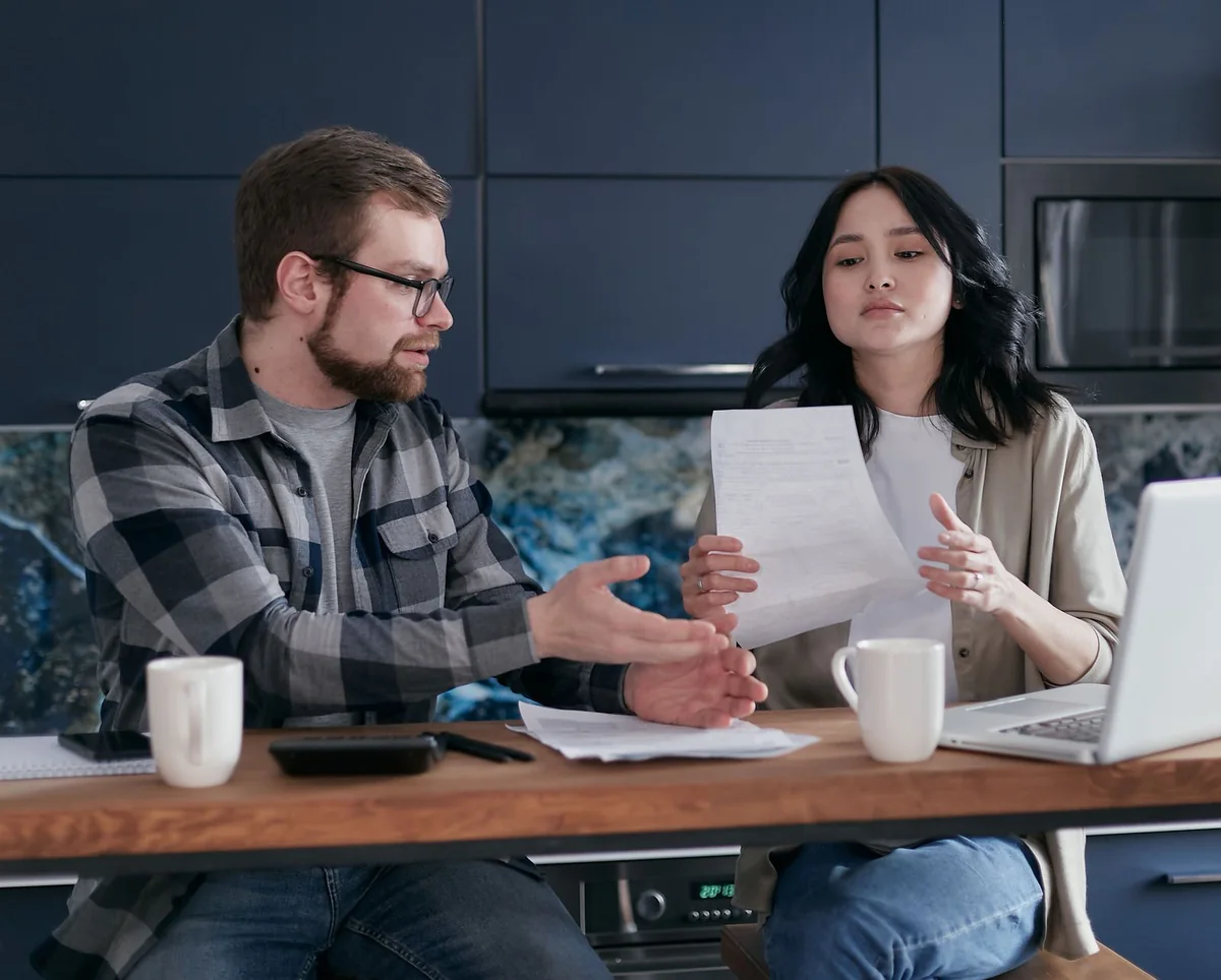 A couple reviewing paperwork at a table to decide options for the marital home